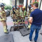 Bomberos de Burgos junto a una arqueta en la calle Vitoria.