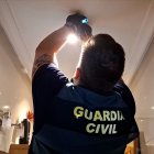 Un agente de la Guardia Civil desmonta la cámara instalada en el sistema de iluminación del baño.