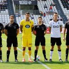 Imagen de los capitanes y el equipo arbitral.
