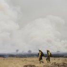 Varios bomberos tratan de extinguir un fuego, a 13 de agosto de 2025, en Miñambres de la Valduerna, León, Castilla y León (España).