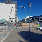 Los peatones caminan por debajo de la maquinaria de obra en la calle Siervas de Jesús.