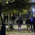 Un grupo de jóvenes con bolsas de supermercado, por una calle de Burgos.
