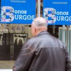 un hombre pasa por delante de un cartel de una campaña anterior de bonos.