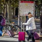 Personas con maletas pasean por las calles de Burgos, en un fin de semana reciente.