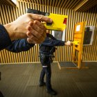 Dos agentes realizan una demostración de uso de la pistola táser.