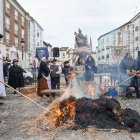 Dos integrantes de la Sociedad Gastronomica de Los Cucos, queman el cerdo antes de ser eviscerado tal y como se hacia antaño.