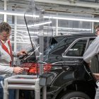 Archivo - Dos trabajadores produciendo un coche en una planta de Audi.