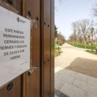 Cartel en una de las puertas de acceso al parque de El Parral, en el que se advierte de que se cierran en la noche de viernes y sábados.