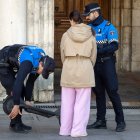 Dos agentes examinan un patinete eléctrico en la plaza Mayor, ante la atenta mirada de su propietaria.