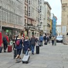 Un numeroso grupo de turistas caminando la semana pasada con sus maletas por la calle de La Paloma.