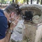 Un hombre se refresca en una fuente.