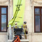 Imagen de dos trabajadores en la fachada de un edificio.