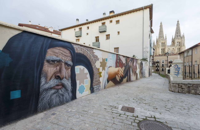 Vista de la calle Embajadores con uno de los personajes del mural en primer término. El representante de la cultura judía. SANTI OTERO