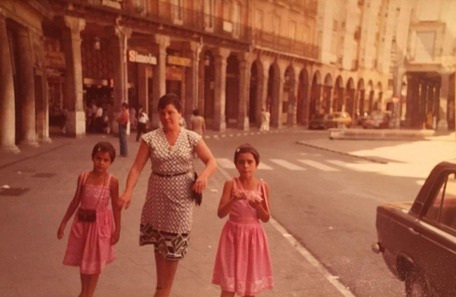 Marga Arroyo con su madre Margarita y su hermana Rosa por una Plaza Mayor con vehículos y muchas ganas de llegar a la Quinta. Allí las manzanas de caramelo eran su perdición, "nunca me las compraron, el algodón de azúcar sí". Ahora a su hija le compra una de las manzanas caramelizadas cada año.