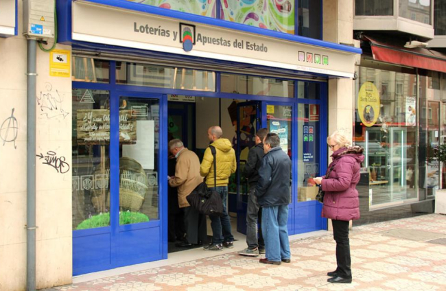 Varios burgaleses esperan su turno para comprar lotería en la administración ‘Don Pepe’ de Gamonal.-JAIME CARAZO