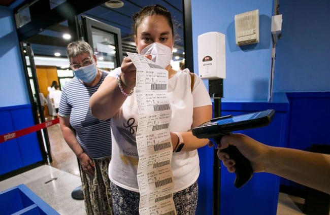Una mujer muestra sus entradas en la primera Fiesta del Cine celebrada en pandemia. TOMÁS ALONSO