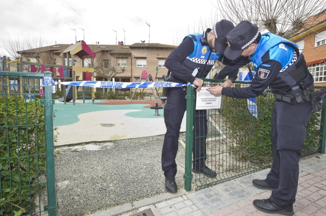 Dos agentes de Policía Local clausuran un parque infantil en Burgos por el coronavirus. / ISRAEL L. MURILLO