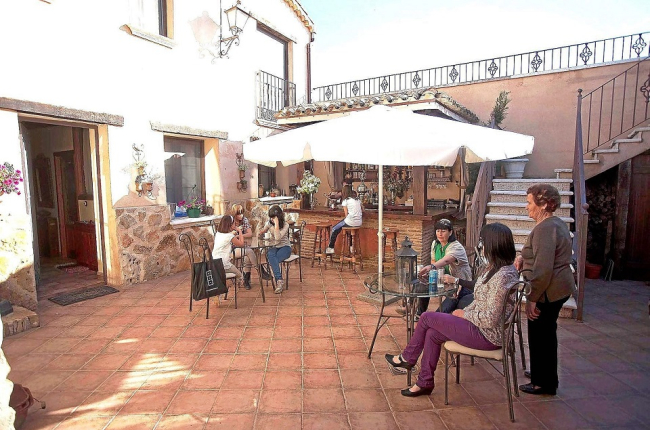 Un grupo de viajeros descansa en el patio de un alojamiento de turismo rural de Valladolid. Horizontal