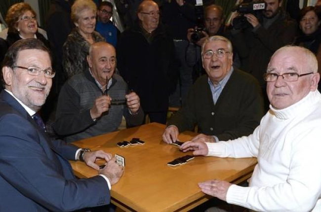 El presidente del Gobierno, Mariano Rajoy, junto a sus compañeros de juego en el Hogar del Pensionista, tras su intervención hoy en un mitin en la localidad vallisoletana de Olmedo.-EFE/Nacho Gallego