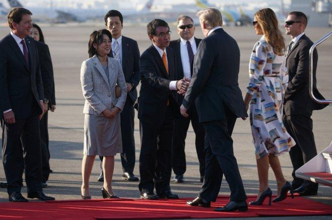 El presidente de EEUU, Donald Trump, y su esposa Melania saludan al ministro de Asuntos Exteriores japonés, Taro Kono, y su esposa Kaori, a su llegada al Aeropuerto de Haneda, en la prefectura de Tokio.-AP / EVAN VUCCI (AP)