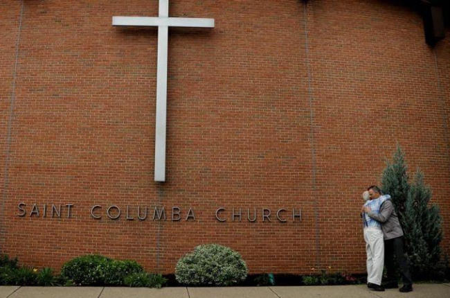 Dos miembros de la Iglesia de Santa Columba, en Bloomsburg (Pensilvania), se abrazan.-CARLOS BARRIA (REUTERS)