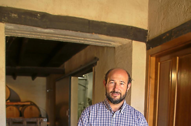 El enólogo Ildefonso Gregorio Hidalgo posa en la entrada de la bodega con sus vinos.-M.T.