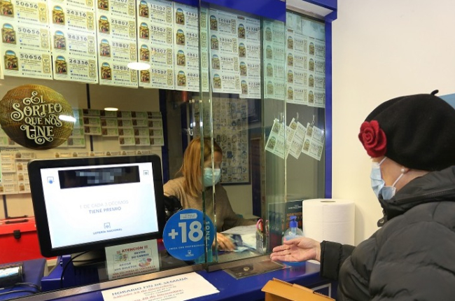 Una mujer compra lotería en una administración. ECB