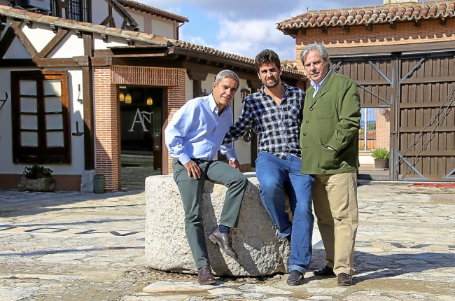 Los hermanos José Luis (i) y Javier (d) Ruiz Madroño posan con Luis Miguel Pérez en el patio de Bodegas Mocén, en Rueda (Valladolid).-M.T.