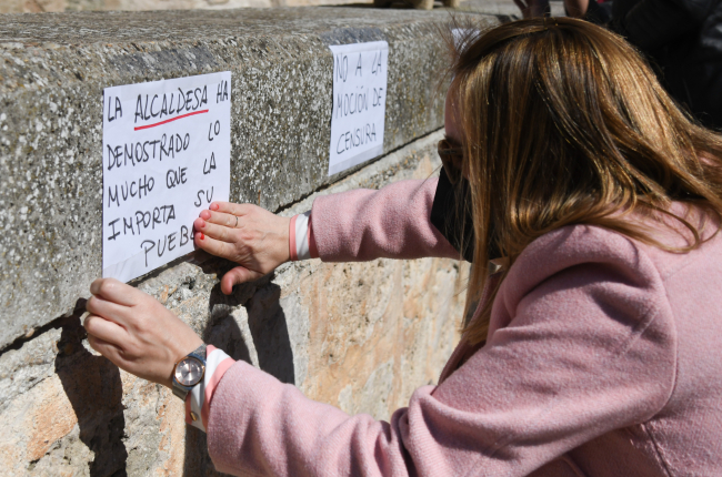 Una mujer coloca un cartel a favor de la alcaldesa de Tórtoles de Esgueva. ICAL