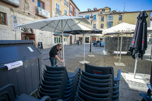 Un trabajador instala las sombrillas para la terraza de hostelería en La Flora. TOMÁS ALONSO