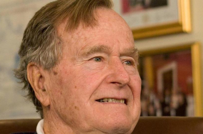 George H.W. Bush sonríe al escuchar al candidato presidencial republicano Mitt Romney, a quien apoyó en la elección del 2012, en un acto en Houston, el 29 de marzo del 2012.-REUTERS / DONNA CARSON