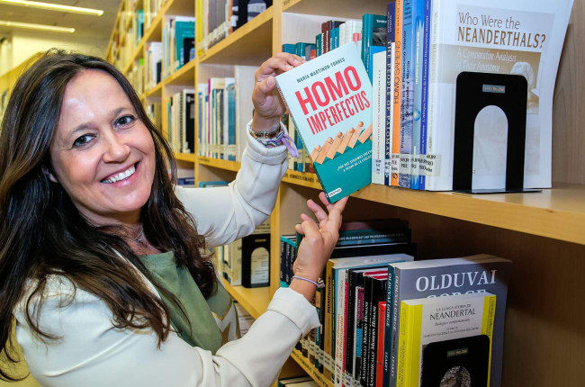 María Martinón posa en la biblioteca del Cenieh con uno de los ejemplares de su primer ensayo divulgativo en solitario 'Homo imperfectus'. TOMÁS ALONSO