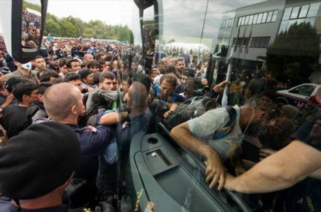 Refugiados suben a un autocar cerca de Heiligenkreuz, en la frontera entre Austria y Hungría, ayer.-AP / CHRISTIAN BRUNA