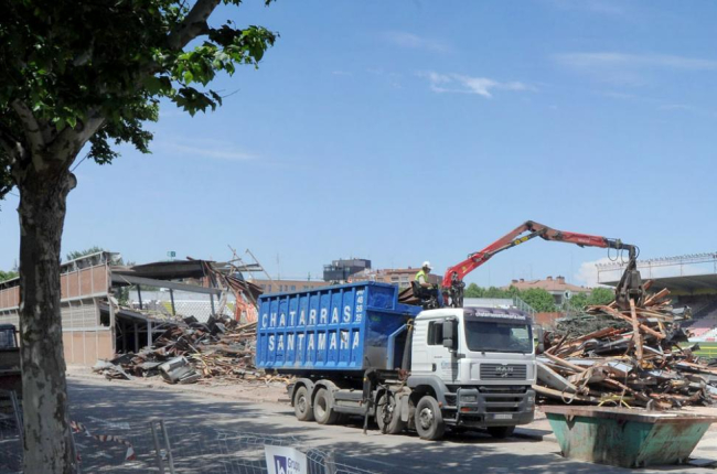 Un camión retira los escombros una vez demolida la mitad de la grada.-ISRAEL L. MURILLO