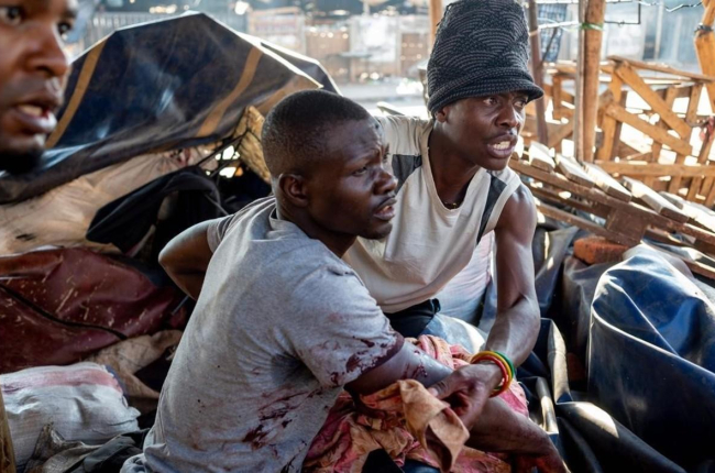 Un hombre ayuda a un herido a salir de una de las zonas conflictivas en el marco de las protestas por el resultado de los comicios en Zimbabue.-YESHIEL PANCHIA (EFE)