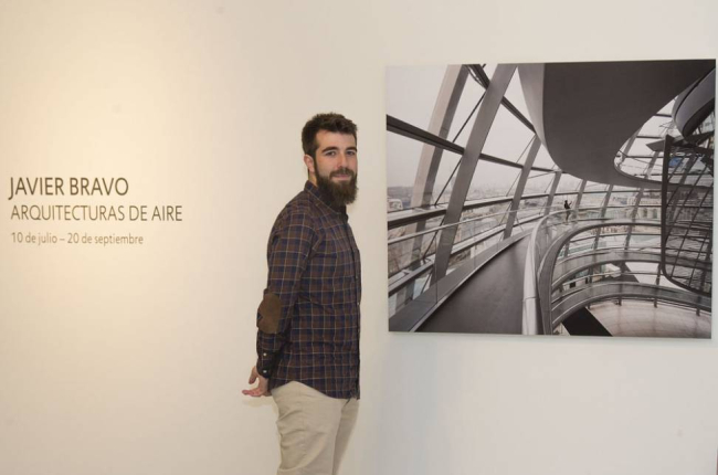 Javier Bravo, ayer tras la presentación de la exposición, posa con una de las imágenes, del famoso Reichstag de Berlín.-ISRAEL L. MURILLO