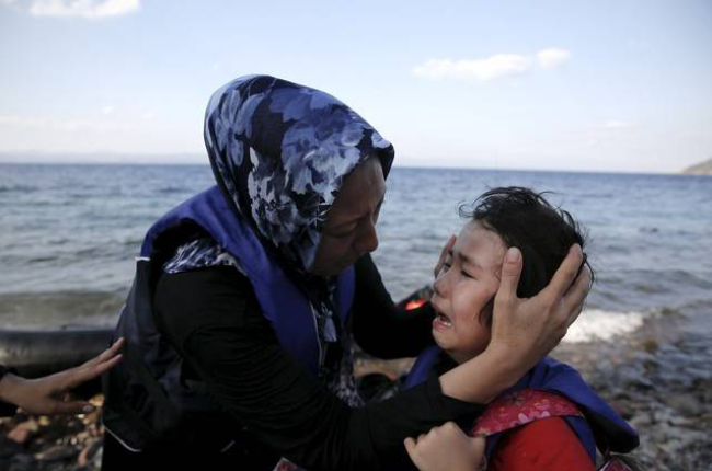 Una mujer afgana tranquiliza a su hija, que llora de miedo después de la travesía por mar entre Turquía y Grecia.-Foto: REUTERS / ALKIS KONSTANTINIDIS