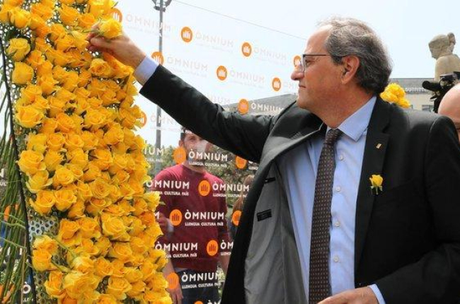 El presidente Quim Torra coloca una rosa amarilla en el mural de Òmnium.-BLANCA BLAY (ACN)