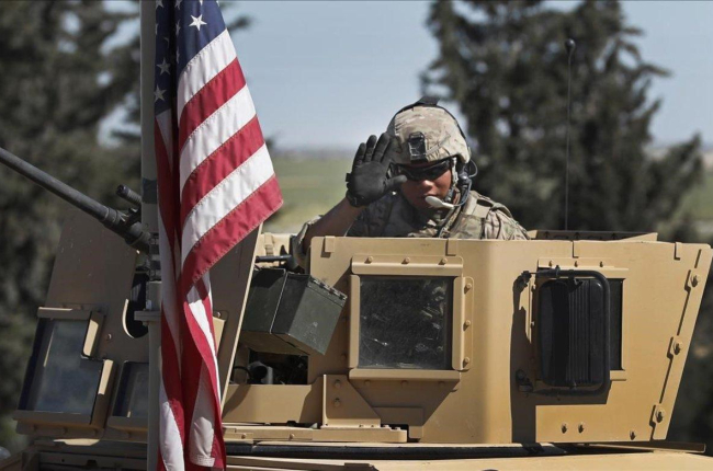 Un soldado de EEUU saluda desde un vehículo blindado en una carretera que conduce a la ciudad de Manbij, al norte de Siria.-HUSSEIN MALLA (AP)
