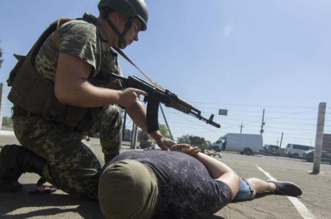 Guardas fronterizos ucranianos arrestan a un intruso durante un simulacro en el área de Donestk.-EFE / IRINA GORBASYOVA