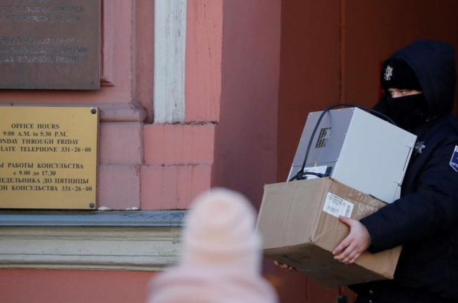 Un agente de seguridad carga con varias cajas a su salida del Consulado General de EEUU en San Petersburgo.-EFE