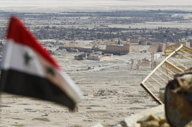 Una bandera siria ondea ante las ruinas de la histórica ciudad de Palmira.-REUTERS / OMAR SANADIKI