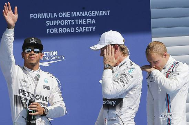Lewis Hamilton, 'pole' en Spa, saluda a los aficionados junto a Nico Rosberg y Valtteri Bottas.-Foto: EFE / VALDRIN XHEMAJ