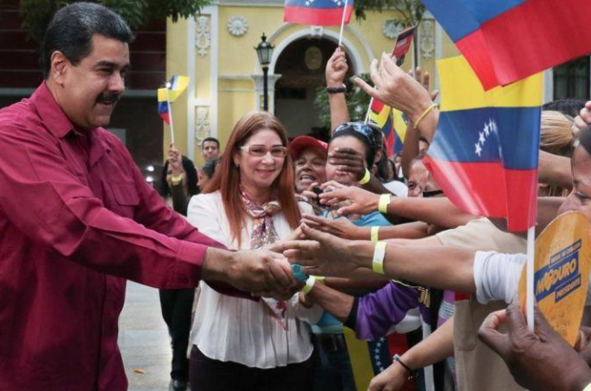 Maduro y su esposa, Cilia Flores, saludan a sus seguidores en un acto en Caracas, el 25 de enero.-EFE