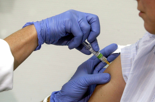 Una persona se vacuna frente a la gripe en un centro médico.- ICAL
