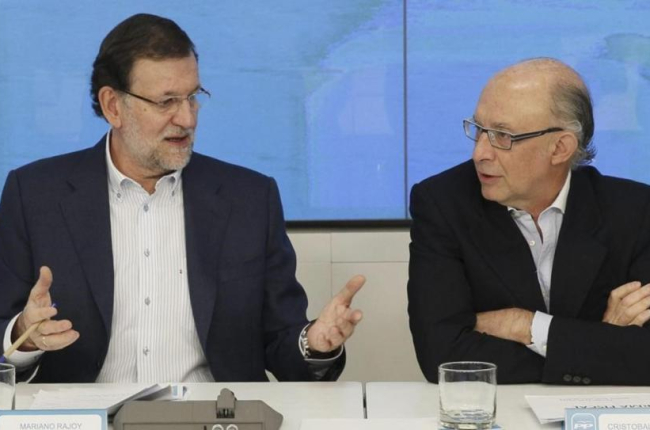 El presidente del Gobierno, Mariano Rajoy, y el ministro de Hacienda, Cristóbal Montoro, en la sede del PP en junio del 2014-PACO CAMPOS