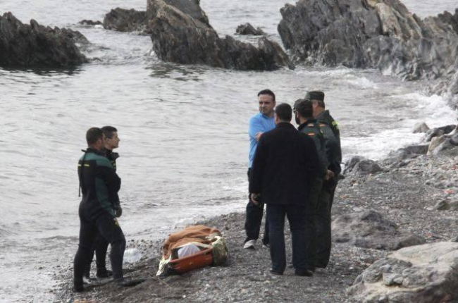 Miembros de la Guardia Civil, junto a uno de los dos cadáveres hallados el sábado en la playa de la Ribera, en Ceuta.-EFE