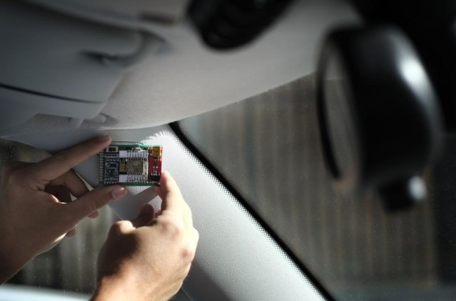 Una persona coloca el sensor en el vehículo para detectar los accidentes.-ENRIQUE CARRASCAL