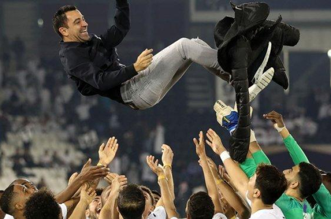 Xavi, manteado por sus jugadores después de ganar la final de la Qatar Cup.-