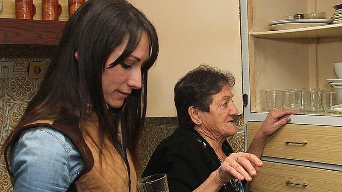 Una empleada del servicio de ayuda a domicilio colabora con una usuaria.-ICAL